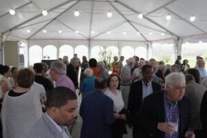 Crowd of people at a reception under a large tent